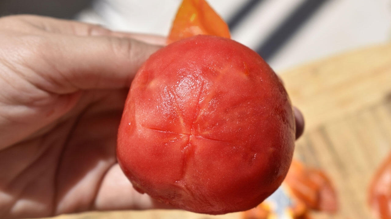 Wenn Sie die Tomate kreuzweise eingeschnitten haben, können Sie die Haut nach dem Kochen einfach abziehen. Wenn Sie die Tomate kreuzweise eingeschnitten haben, können Sie die Haut nach dem Kochen einfach abziehen.